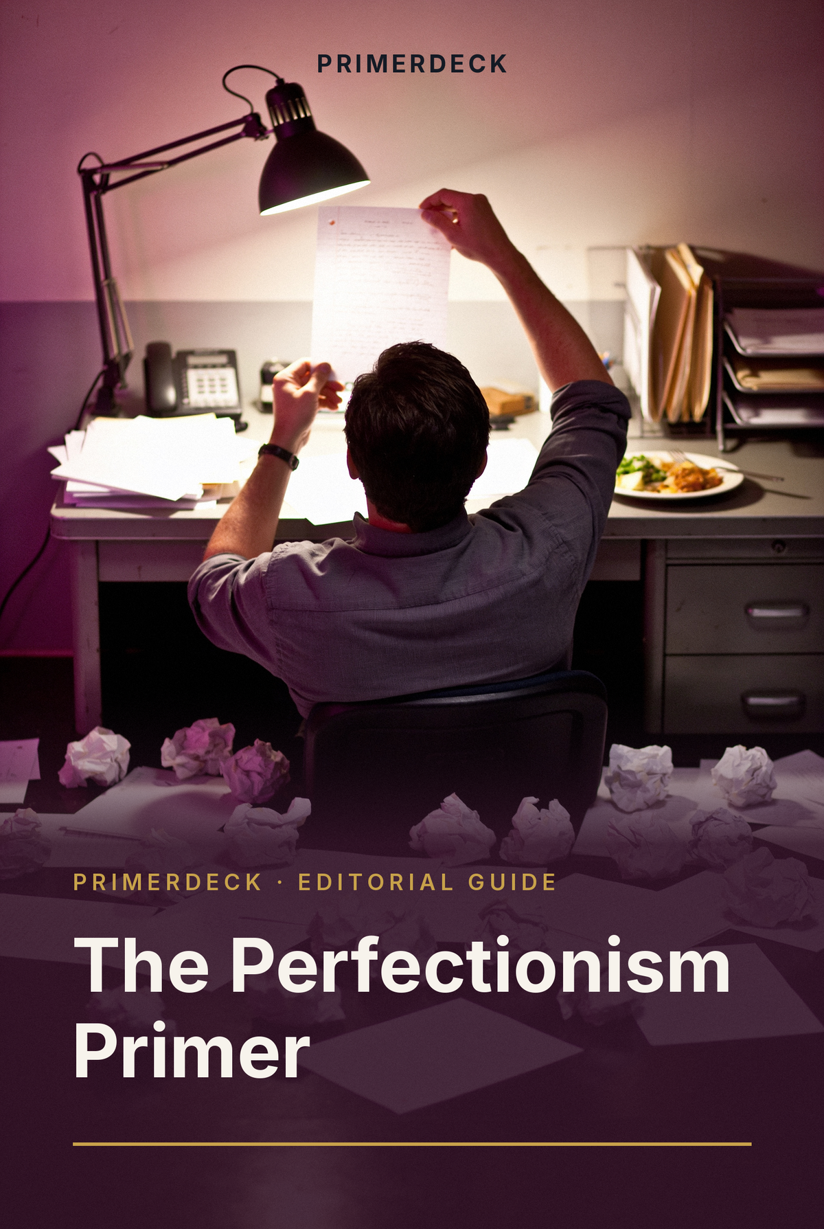 PrimerDeck cover: The Perfectionism Primer: man examines a single page under a desk lamp, crumpled drafts scattered around him
